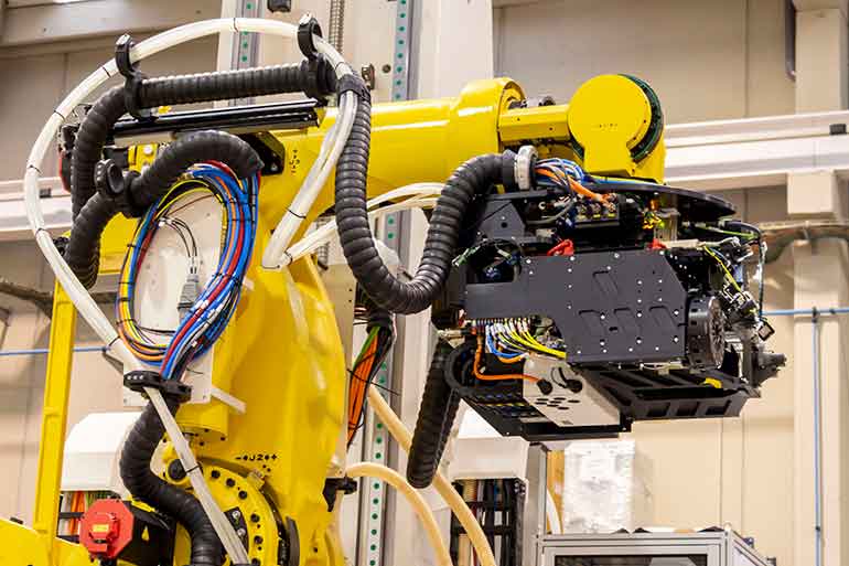 Robotic arm working on an aircraft fuselage.