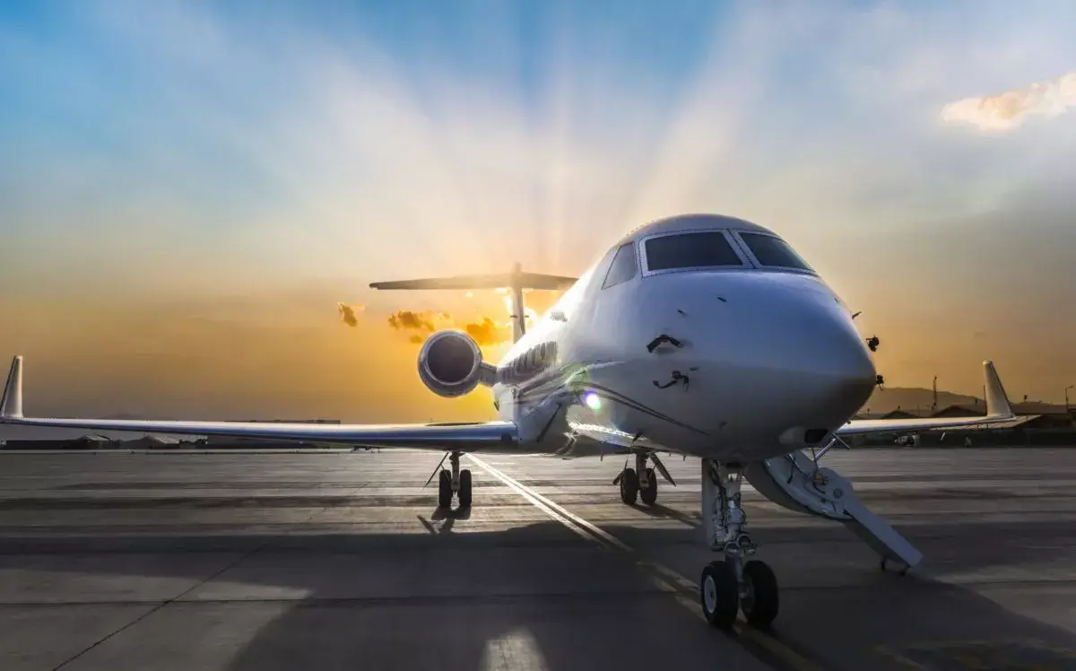 Private jet on a tarmac at sunset, suggesting charter potential.