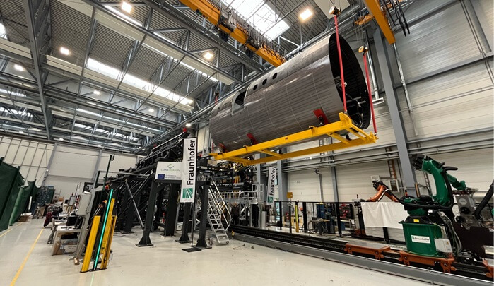 A clean, futuristic assembly line with aircraft fuselages being joined.